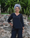 top de seda cuello pico y manga tres cuartos. ccolor negro